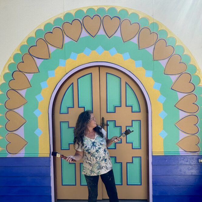 artist anita revel stands in front of her rainbow mural Arcoíris