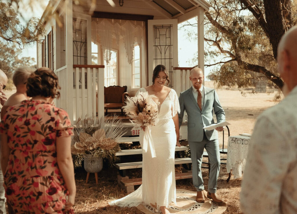 bride and groom on the steps of big love tiny chapel and surrounded by guests